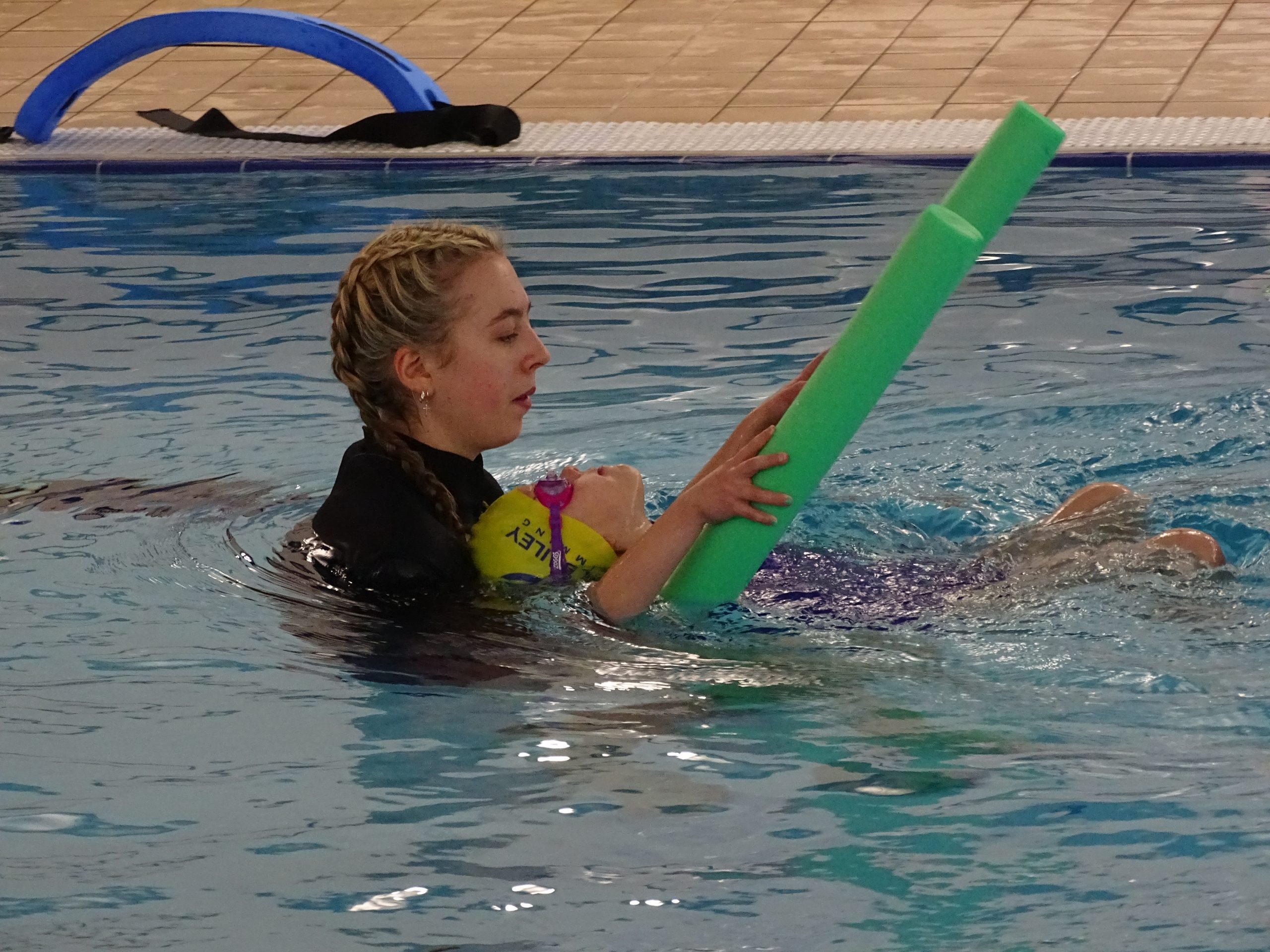 Teacher helping swimmer